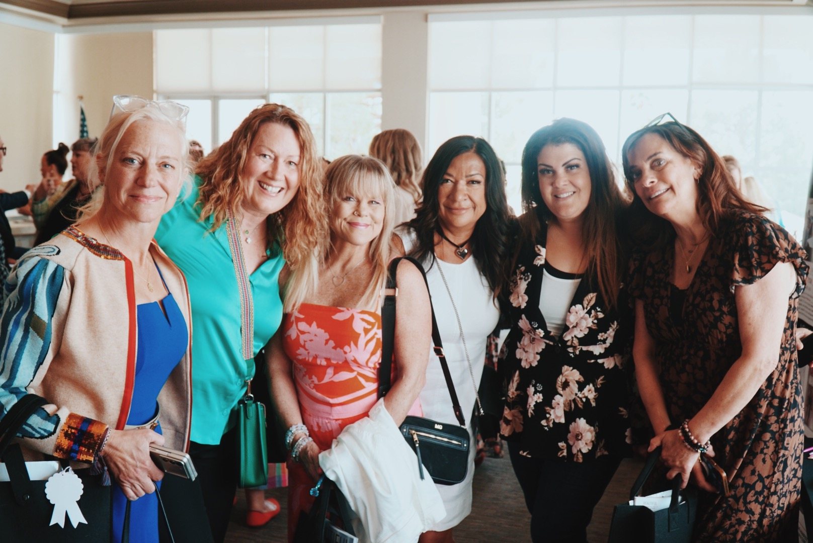 Women smiling together at an OWN IT event